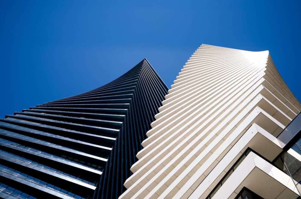 Low angle shot of black and white towers under blue sky